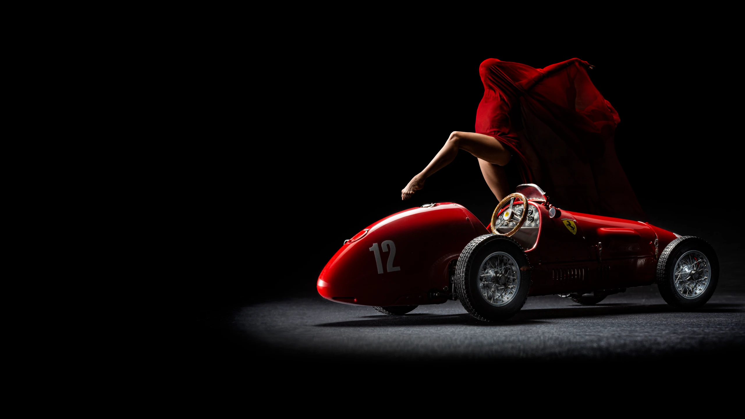 Ferrari 500 F2 rossa fotografata in studio su fondo nero con ballerina in abito rosso – fotografia pubblicitaria PixelXpixeL Siracusa